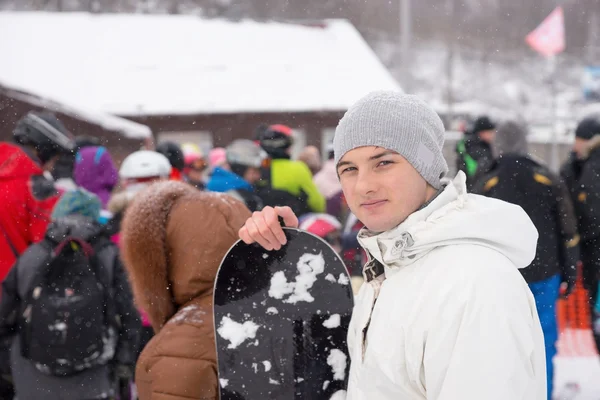 Młody snowboardzista w zatłoczonym resort — Zdjęcie stockowe