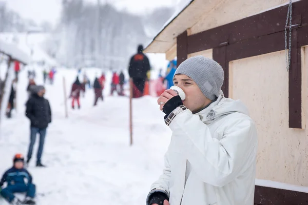 Ung man dricka kaffe på en ski resort — Stockfoto