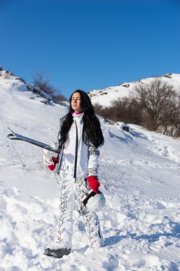 Kadın kayakçı ekipman ile tepeye yürüyüş