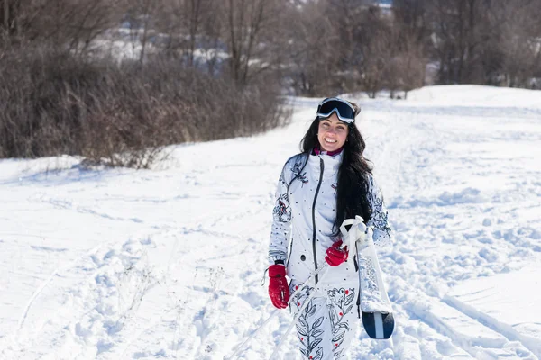 Kameraya gülümseyen kar adlı genç kadın kayakçı — Stok fotoğraf