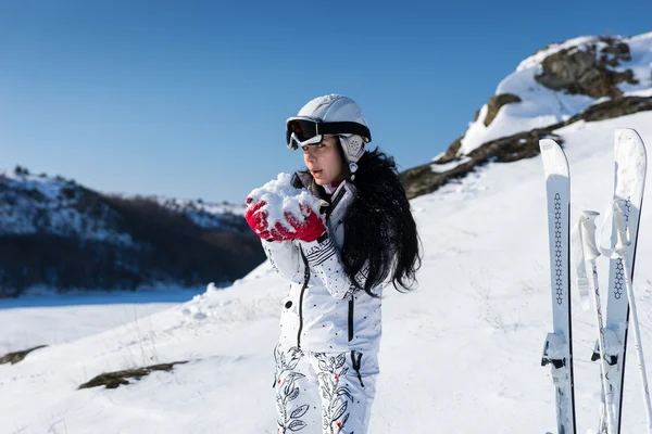 Лыжник, формирующий снежный ком в руках — стоковое фото