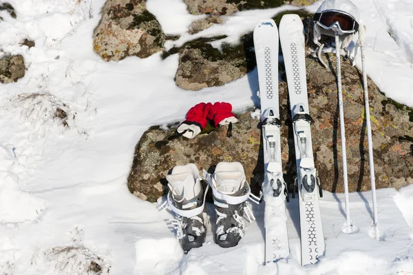 Skidutrustning lutande på stenar och snö — Stockfoto