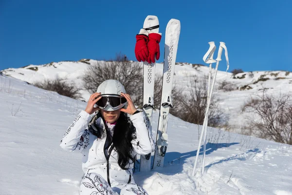 Mujer esquiadora poniéndose el casco antes de esquiar — Foto de Stock