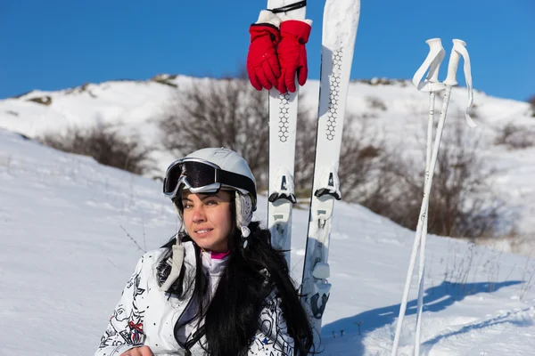 Female Skier in Helmet Sitting on Hill with Skis — стокове фото