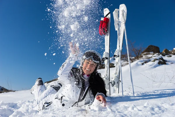 Esquiadora acostada sobre el estómago y arrojando nieve —  Fotos de Stock