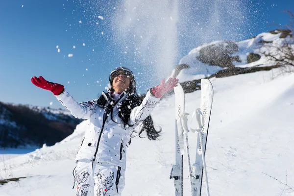 Brincalhão feminino esquiador jogando neve no ar — Fotografia de Stock