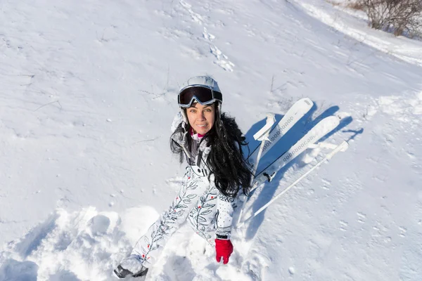 女滑雪者坐在阳光明媚的雪山腰上 — 图库照片