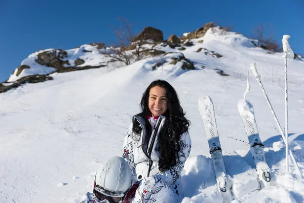 Narciarz kobieta siedzi na Snowy wzgórza z nart — Zdjęcie stockowe