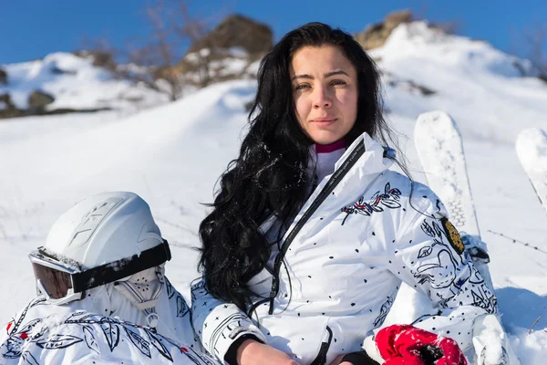 Tepe üzerinde oturan kask ile kadın kayakçı — Stok fotoğraf