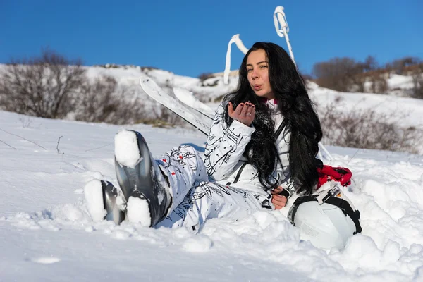 Kadın kayakçı öpücük kameraya güneşli günde üfleme. — Stok fotoğraf