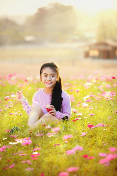 Poco asiático chica soplando jabón burbujas —  Fotos de Stock
