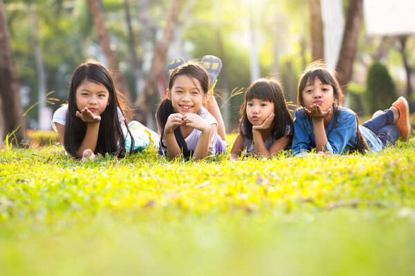 Little asian girls laying on the green grass