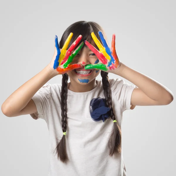 Liten asiatisk tjej med henne händer i färg — Stockfoto