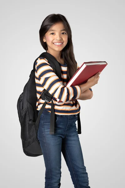 Jovem menina asiática de pé e segurando livros — Fotografia de Stock