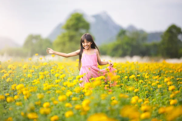 Liten asiatisk tjej i blomma fält — Stockfoto