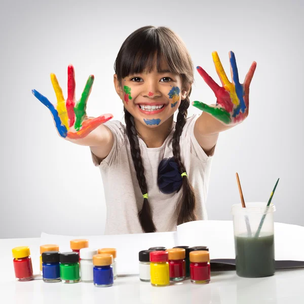 Aziatische meisje met haar handen in de verf — Stockfoto
