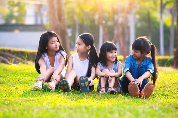 Cuatro niños sonrientes felices jugando en el parque —  Fotos de Stock