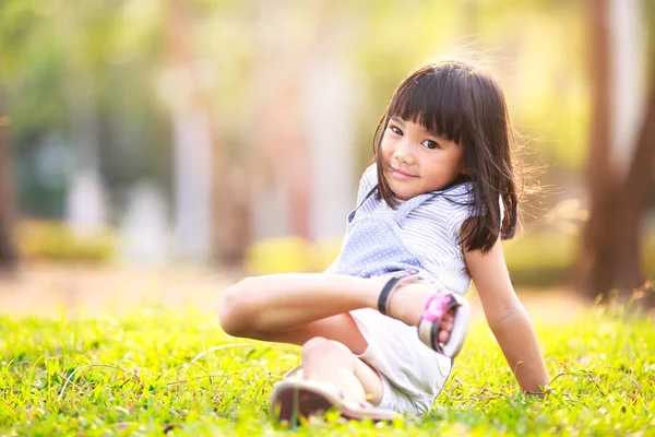 Pouco menina asiática na grama no jardim — Fotografia de Stock