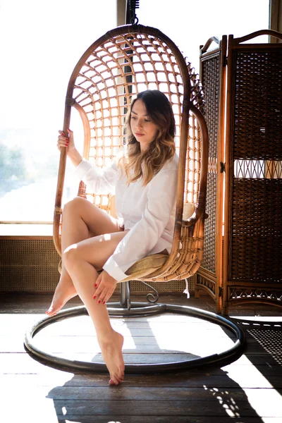 Chica sentada en el estudio en un columpio — Foto de Stock