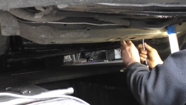 Mecânico trabalhando debaixo de um carro — Vídeo de Stock