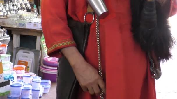 Man in rode klederdracht in Marrakech markt — Stockvideo