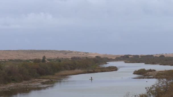 Человек пересекает африканскую реку в Марокко на плоту — стоковое видео