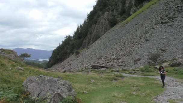 Mujer en las montañas lee mapa y camina con sonrisa — Vídeo de stock