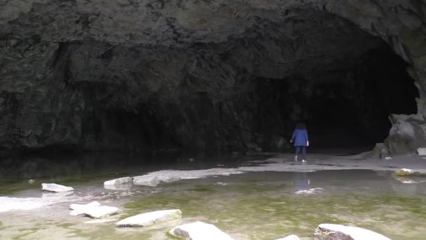 Frau verschwindet in der dunklen Höhle — Stockvideo