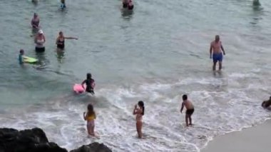 CORNWALL, İngiltere, BİRLİK KINGDOM - CRCA AĞUSTOS, 2020: Sıcak bir yaz gününde deniz suyunda insanların, yetişkinlerin ve çocukların yüksek açılı görüntüsü.