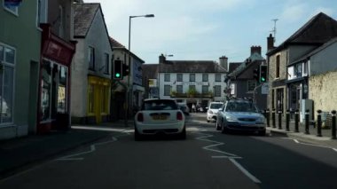LLANDOVERY, WALES, UNITED KINGDOM - CIRCA EPTEMBER, 2020: Galler pazar kasabasında ana yola çıkmak, Craft Centre, Castle Hotel, WWW2 anıtını geçmek. Arabanın ön cam görüntüsü.