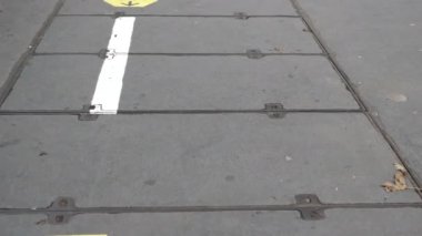 Üzerinde sosyal uzaklık işaretleri olan kirli kaldırımlarda yürüyorum..