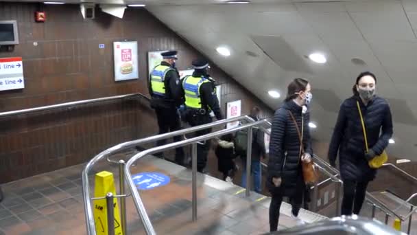 2020年11月28日 两名身穿制服的警察和其他戴口罩的人一样 在验尸官大流行期间爬下楼梯进入邦德街地铁站 — 图库视频影像