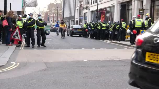 ロンドン イギリス 11月 2020 左側の保護面マスクを身に着けている警官のグループは 老人を逮捕し オックスフォードストリートとの角に警察官の大きなグループの後ろに彼を歩く — ストック動画