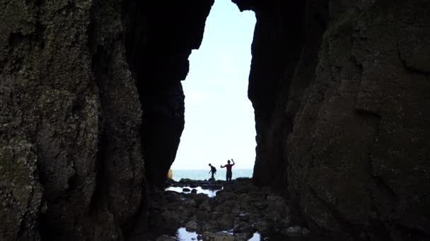 Невпізнавані Силуети Пари Йдуть Всередину Великої Високої Діри Скелі Фоні — стокове відео