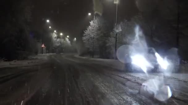 雪の中 夜に農村部のイギリスで運転 フロントガラスに雪を溶かすと 対向車のヘッドライトがぼやけて歪んでしまいます — ストック動画