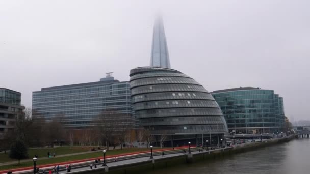 在英国伦敦 一些身份不明的人走过河岸上的现代玻璃建筑 拍摄了泰晤士河两边的全景照片 — 图库视频影像