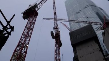 Yeni gökdelen inşaatındaki vinçler aşağı eğildi.