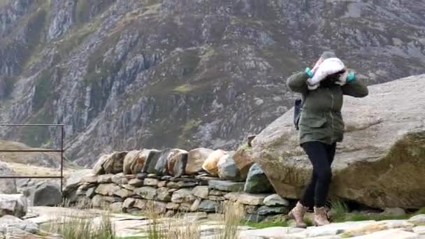 Galler Dağlarında Güçlü Bir Rüzgarda Yürümeye Çalışan Gülen Bir Kadın — Stok video