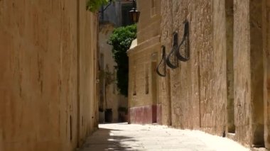 Ortaçağ 'ın dar, açık kahverengi renkli ve Malta' nın eski Mdina kentinin caddesinden uzaklaşmak..