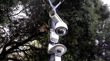 Üç farklı açık hava güvenliğinin daha yakın görüntüsü, kırmızı gösterge olarak çalışan kameralar.