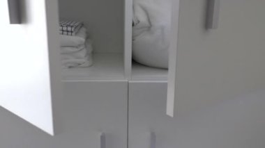 Beyaz renkli yatak keten dolap. Çift kapı açılıyor ve kapanıyor..