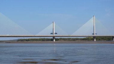 Panning shot of beautiful long Mersey Gateway Bridge over river Mersey and Manchester Ship Canal between Widnes and Runcorn in Cheshire, Warrington power station seen in the background.