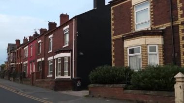 İngiltere 'nin kuzeybatısındaki Hindley, Wigan' daki ana yolda kırmızı tuğlalı evler. Akşam olmadan önce hareket halindeki arabadan görüntü.