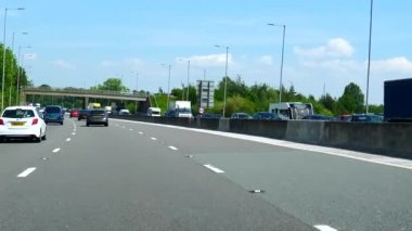 A494 Highway, Wales, UNITED KINGDOM - CIRCA HAZİRAN 2021: Kuzey Galler 'de otoyolda araba ön cam manzarası. Ters yönde trafik sıkışıklığı, köprünün üstündeki otobüs..