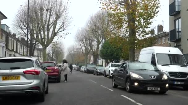 ロンドン イギリス Circa 11月 2020 秋にキルバーン地区の住宅街のキャベンディッシュ道路上の車のフロントガラスビューの運転 一部の人々は屋外で保護顔マスクを着用 — ストック動画