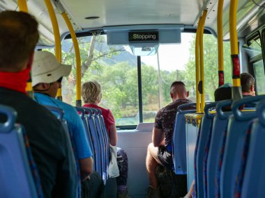 Turistlerin arka görüntüsü, dağlarda seyahat eden çift katlı otobüsteki yürüyüşçüler, arka plandaki seçici odaklanma.