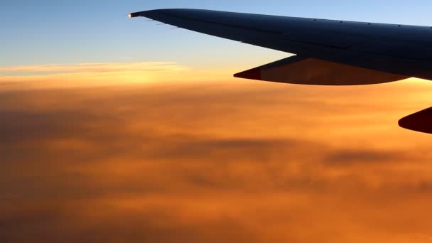 Airplane wing above orange clouds — Stock Video