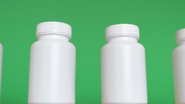 Fila de botellas blancas sobre fondo verde — Vídeos de Stock