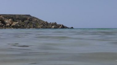 Deniz dalgalanma closeup, uzak kayalar