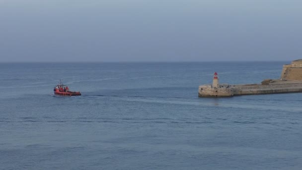 Rotes Motorboot passiert Leuchtturm — Stockvideo